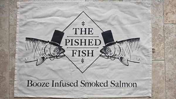 Logo of 'The Pished Fish' with two fish wearing top hats on a textured surface.
